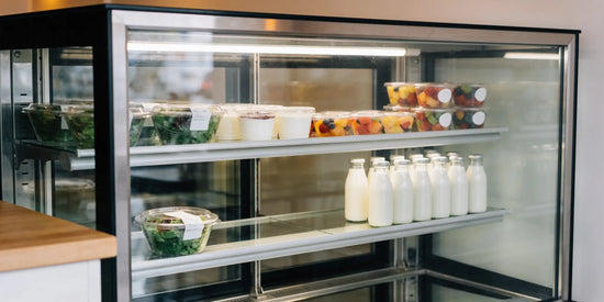 Kyl i café med datummärkta sallader, yoghurt, fruktbägare och mjölkflaskor sorterade enligt FEFO