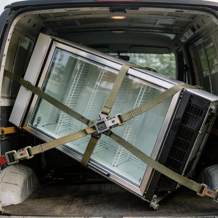 Displaykyl transporteras liggande i skåpbil, fastspänd med spännband