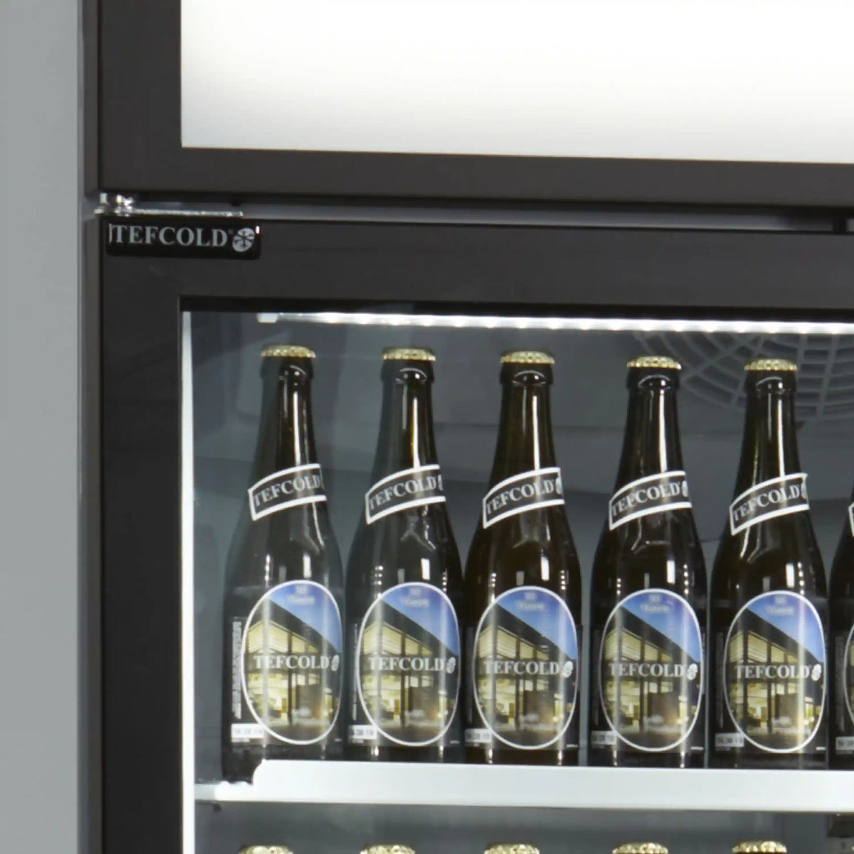 Närbild på glasdörr och LED-belysning i TEFCOLD FSC1600H displaykyl med flaskor.