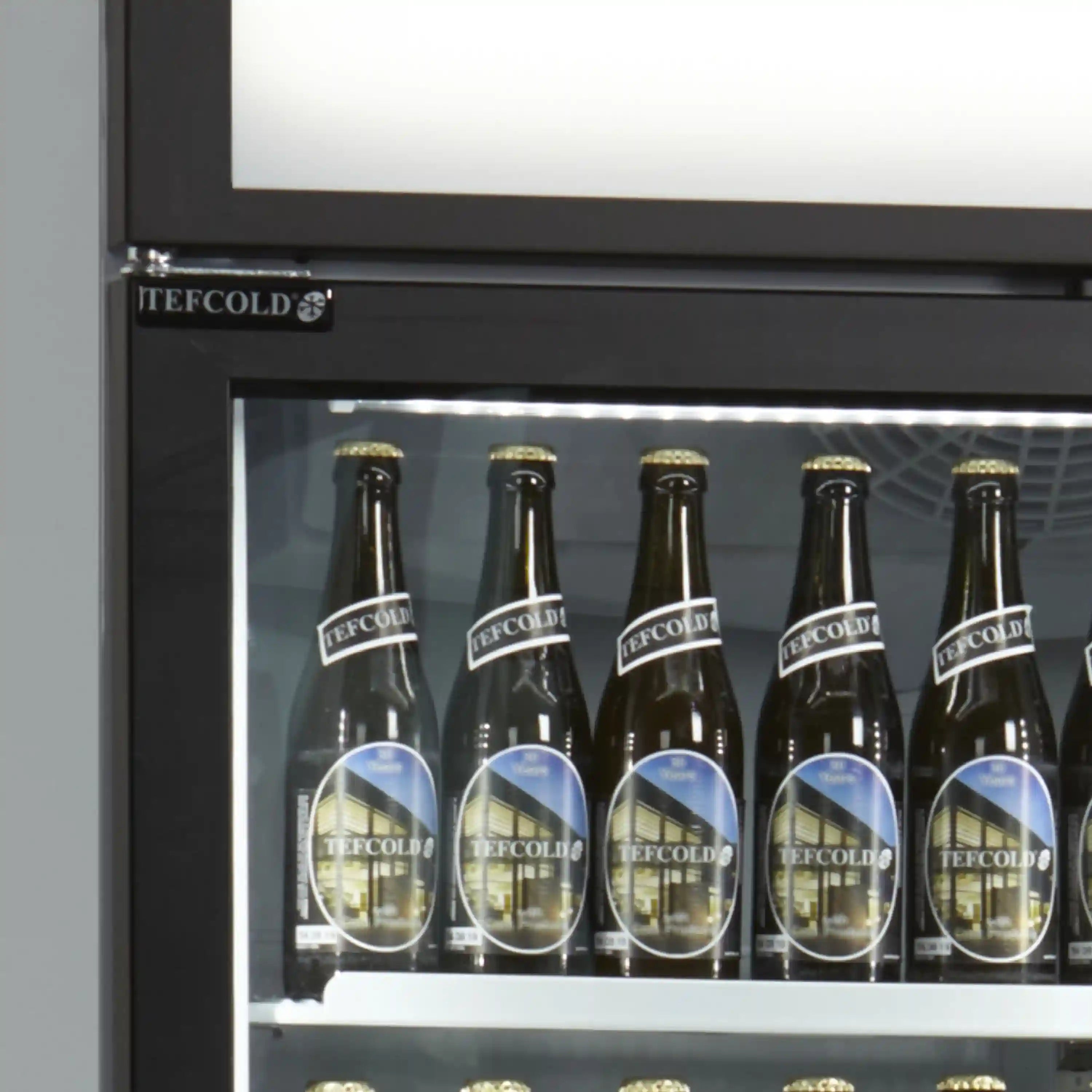 Närbild på glasdörr och LED-belysning i TEFCOLD FSC1600H displaykyl med flaskor.