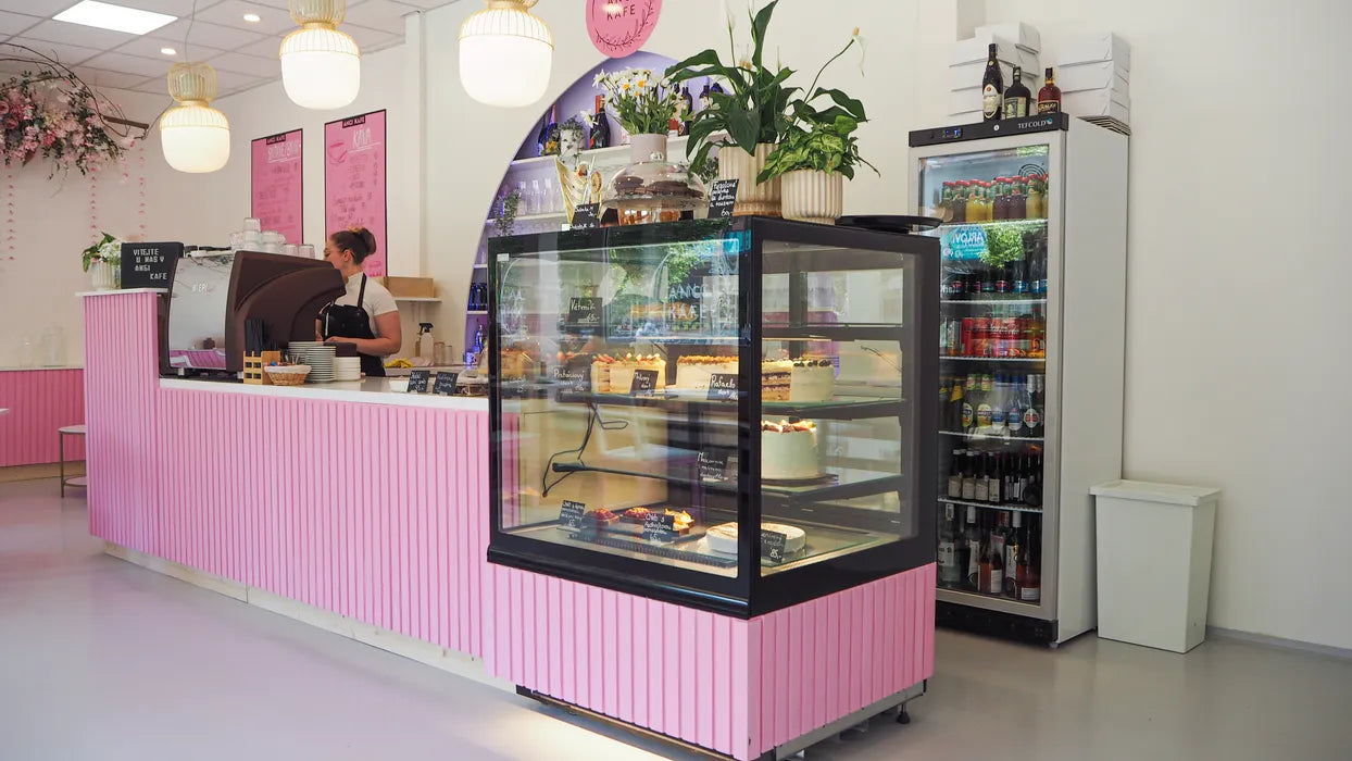 Tefcold UR400G Displaykyl placerad i café med rosa inredning och kakmonter.
