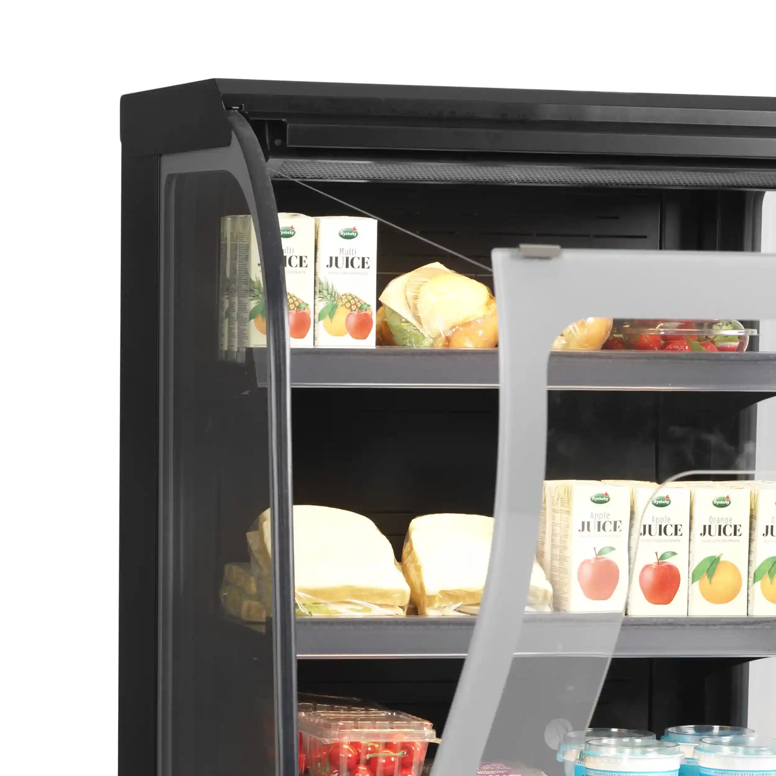 Öppnad TEFCOLD NOC60CC Kylmonter med juice och färdiga mellanmål på hyllorna.